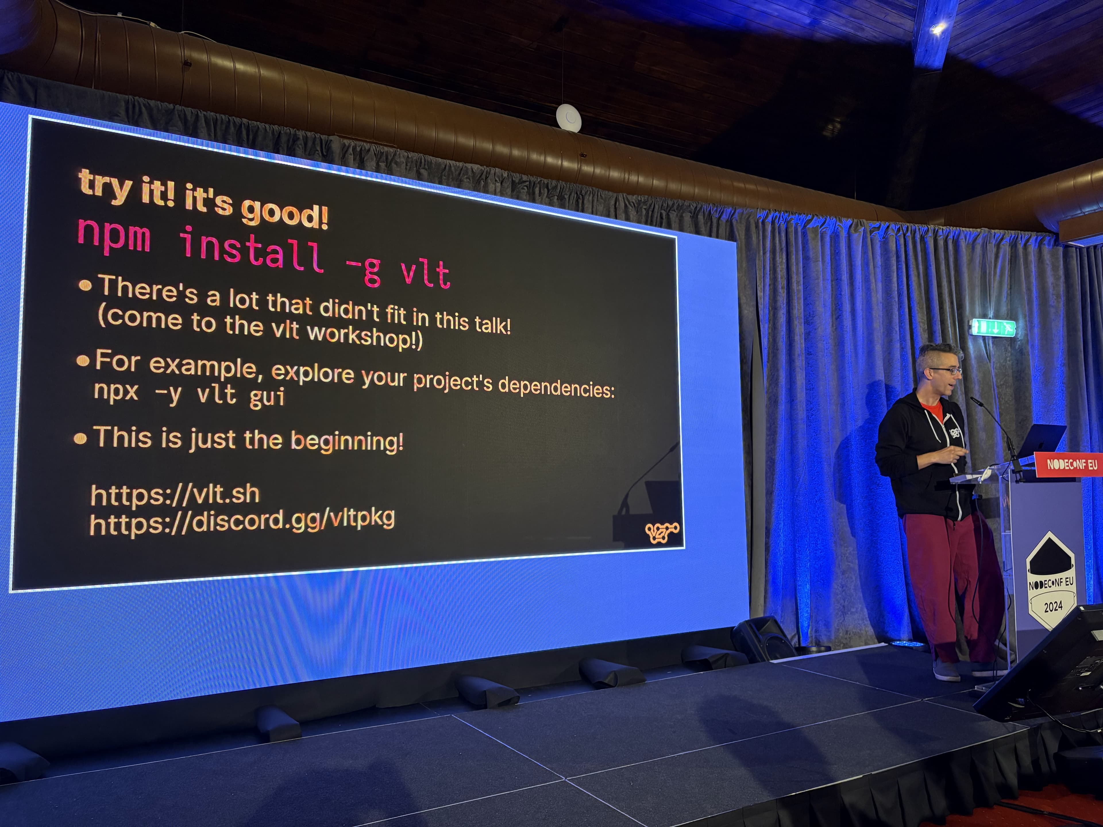 Isaac standing at a lectern talking to the audience. To the left is a large slide of text that reads: "try it! it's good!
npm install g vlt
There's a lot that didn't fit in this talk! (come to the vit workshop!)
For example, explore your project's dependencies: npx -y vlt gui
This is just the beginning!
https://vit.sh
https://discord.gg/vItpkg"